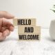 hello-and-welcome-symbol-concept-words-hello-and-welcome-on-wooden-blocks-businessman-hand-photo